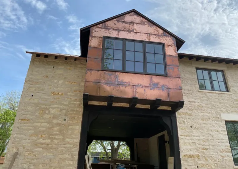 Copper metal panel facade on a stone building for Skylight Installation in Winnetka